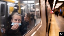 ARCHIVO - Un pasajero mira hacia el andén mientras viaja en un tren hacia el norte en la estación de metro de 36th Street durante el viaje matutino, en Nueva York, el 13 de abril de 2022.