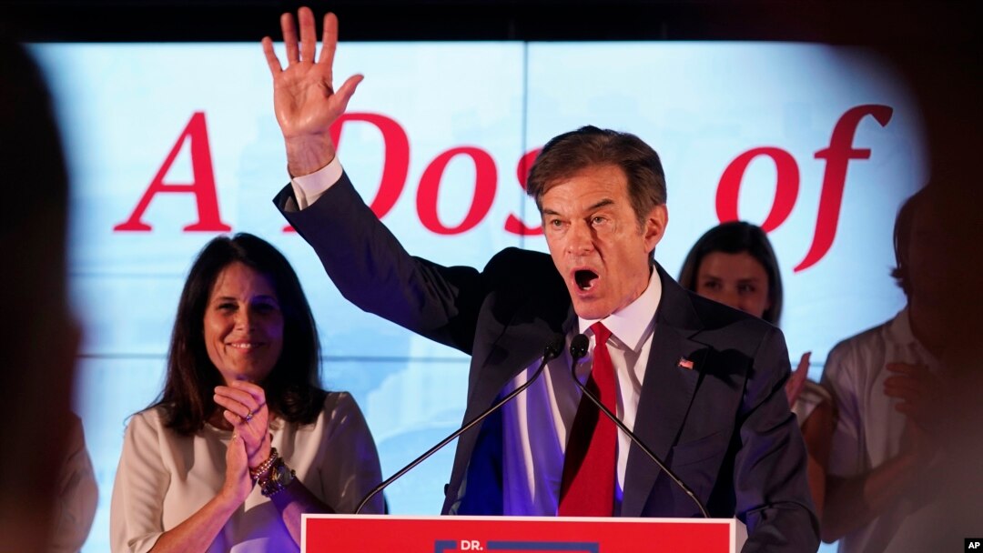 Mehmet Oz, candidato republicano al Senado de EEUU en Pensilvania, a la derecha, saluda frente a su esposa, Lisa, mientras habla en una reunión de elecciones primarias nocturnas en Newtown, Pensilvania, el 17 de mayo de 2022.