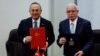 FILE - Turkish Foreign Minister Mevlut Cavusoglu and Palestinian Foreign Minister Riyad al-Maliki hold documents as they sign agreements during a meeting, in Ramallah, in the Israeli-occupied West Bank, May 24, 2022. 