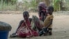 FILE - In this video image, residents watch as Rwandan soldiers patrol a village in Cabo Delgado province, Mozambique, Aug. 9, 2021. The U.N. says it needs an immediate infusion of funds to continue to help feed 1 million people displaced by conflict.