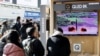 People watch a TV broadcasting a news report on North Korea firing a ballistic missile off its east coast, in Seoul, South Korea, Dec. 18, 2022. 