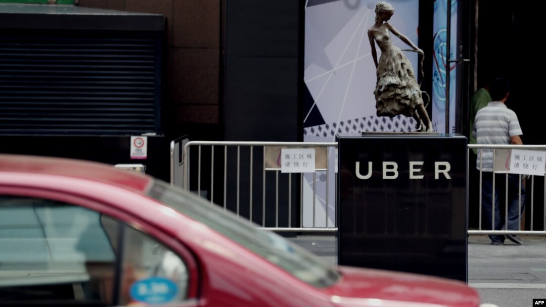 A taxi passes by an Uber station outside a shopping mall in Beijing. Uber is planning on bringing its UberEats to 22 more cities, but it's unclear if Beijing is among them. 