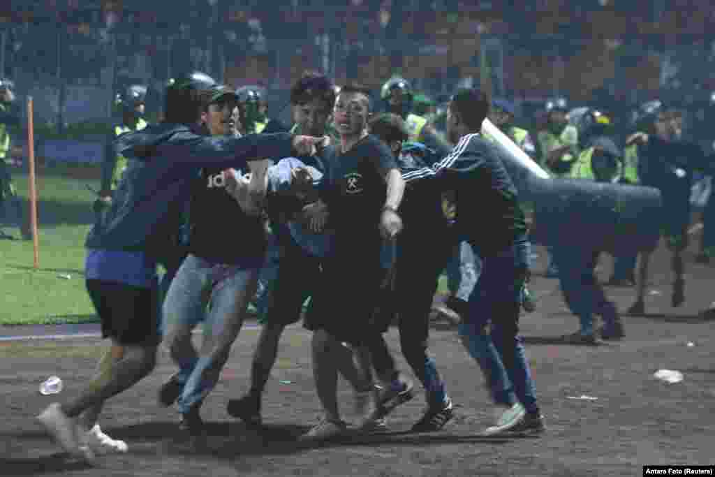 ရဲတပ်ဖွဲ့က ပစ်လိုက်တဲ့ မျက်ရည်ယိုဗုံးထိမှန်ပြီး ဒဏ်ရာရသွားသူတယောက်ကို တခြားဘောလုံးပရိသတ်တွေက ဝိုင်းဝန်း ကူညီ ကယ်ထုတ်ပေးခဲ့ကြပါတယ်။