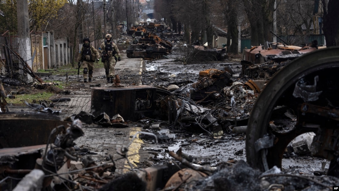 FILE - Ukrainian soldiers walk amid destroyed Russian tanks in Bucha, on the outskirts of Kyiv, Ukraine, April 3, 2022. 