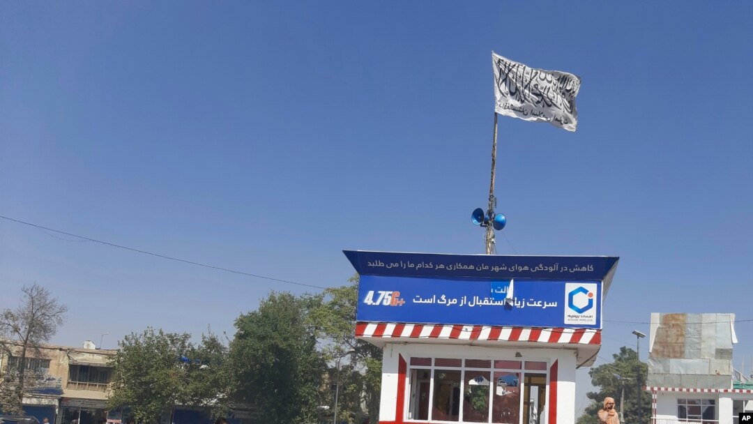 Una bandera talibán ondea en la plaza principal de la ciudad de Kunduz después de los enfrentamientos entre las fuerzas de seguridad talibanes y afganas, en Kunduz, Afganistán, el domingo 8 de agosto de 2021.