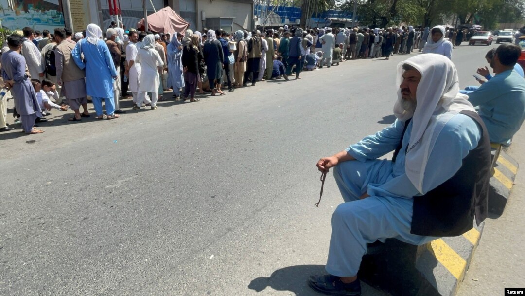 Afganos en Kabul, la capital de Afganistán, hacen largas filas para extraer dinero de los bancos después de que los talibanes se hicieron con el poder a mediados de agosto de 2021. 