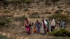 FILE - People walk from a rural area towards a nearby town where a food distribution operated by the Relief Society of Tigray was taking place, near the town of Agula, in the Tigray region of northern Ethiopia on May 8, 2021