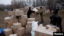 FILE - People handle boxes with humanitarian aid after an apartment block was heavily damaged by a Russian missile strike, amid Russia's attack on Ukraine, in Dnipro, Ukraine, Jan. 16, 2023. 