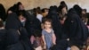 FILE - Families of Islamic State militants are seen after they surrendered themselves to the Kurdish Peshmerga forces in al-Ayadiya, northwest of Tal Afar, Iraq, Aug. 30, 2017.