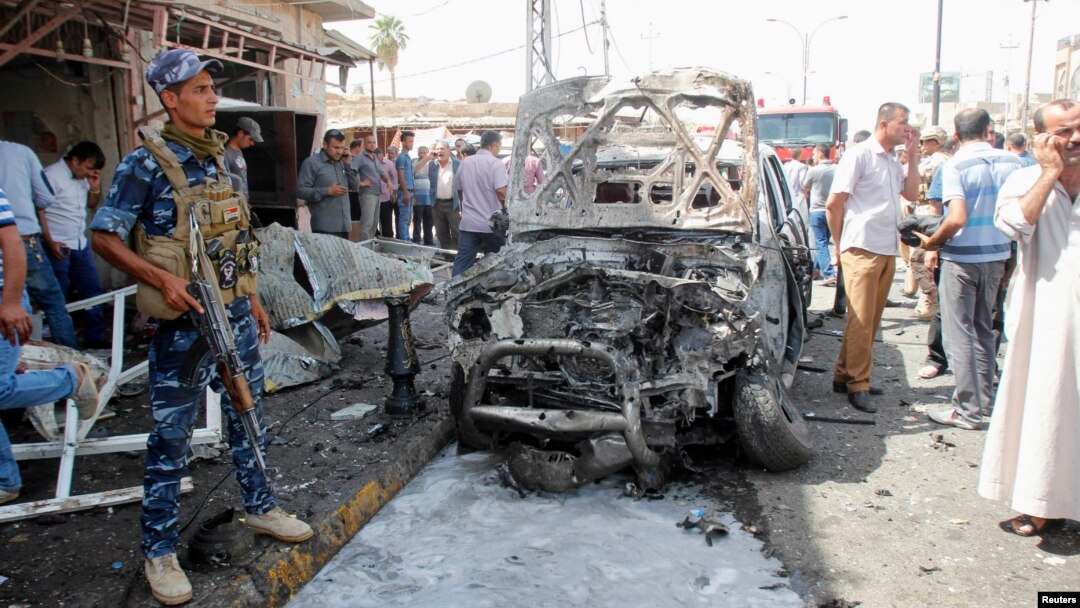 A policeman stands guard at the site of a car bomb attack in Kirkuk, Sept. 19, 2014.