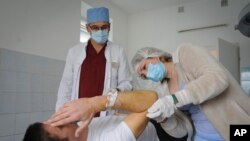 FILE - Ukrainian doctor Oleh Duda, centre, examines a patient at the hospital in western city of Lviv, Ukraine, Nov. 26, 2022. 