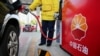 FILE - A gas station attendant pumps fuel into a customer's car at a PetroChina station in Nantong, Jiangsu province, China, March 28, 2018. China's demand for road and air transport fuels may have passed its peak, the International Energy Agency (IEA) said on Feb. 13, 2025.