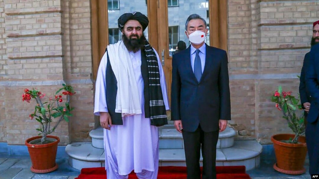 This handout photo released by the Taliban Foreign Ministry shows Taliban Foreign Minister Amir Khan Muttaqi (L) posing with China's Foreign Minister Wang Yi in Kabul on March 24, 2022.