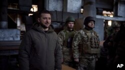Nan foto sa a ke Biwo Lapres Prezidans Ikren nan pibliye, Prezidan Volodymyr Zelenskyy (a goch) pale ak solda nan lye kote youn nan batay pi fewos lage ak Larisi a dewoule, Bakhmut, 20 Desanm, 2022. 