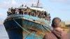 FILE - Migrants stand onboard a fishing boat at the port of Paleochora, following a rescue operation off the island of Crete, Greece, Nov. 22, 2022.