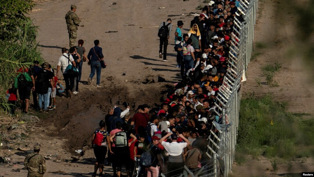 Migrantes que buscan asilo, en su mayoría de Venezuela y Cuba, son detenidos por agentes de Aduanas y Protección Fronteriza de EEUU después de cruzar el río Grande hacia suelo estadounidense desde México en Eagle Pass, Texas, el 13 de julio de 2022.