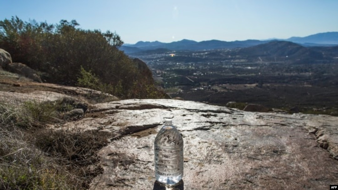 Voluntarios de la organización sin fines de lucro Border Angels dejan agua en un área remota de las montañas cerca del final de la cerca en la frontera entre Estados Unidos y México, en Tecate, California, el 29 de diciembre de 2018.