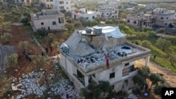 Moun enspekte yon kay ki detwi apre yon operasyon milite Ameriken nan vilaj Siryen Atmeh nan pwovens Idlib ki touye yon lide gwoup teworis Eta Islamik la.
