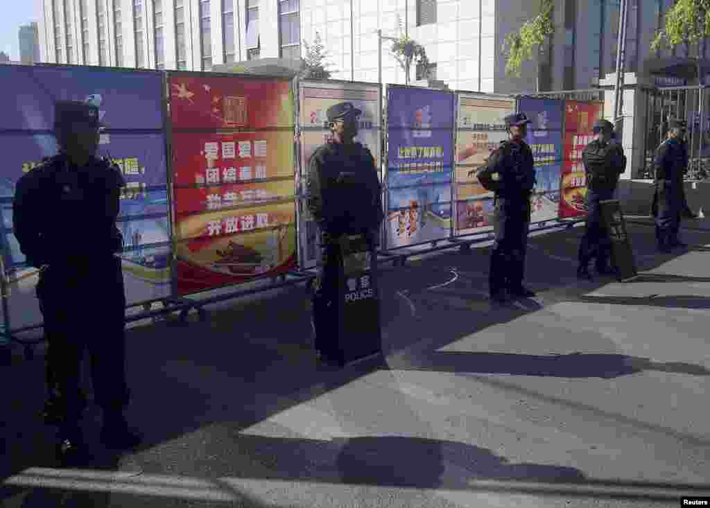 携带防暴装备的警察在新疆乌鲁木齐中级法院附近的检查站站岗，2014年9月17日这家法院审理伊力哈木的案子。 