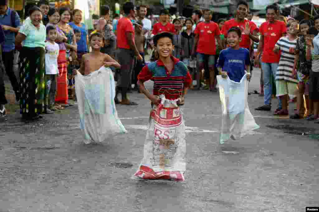 Children take part in a sack race during Myanmar's 71st Independence Day in Yangon, Myanmar.