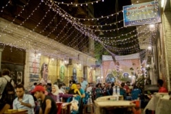 The introduction in recent years of lower-consumption LED bulbs mean many Cairo residents, like patrons and this street café, can continue to enjoy bright lights on a summer’s eve. (H. Elrasam/VOA)