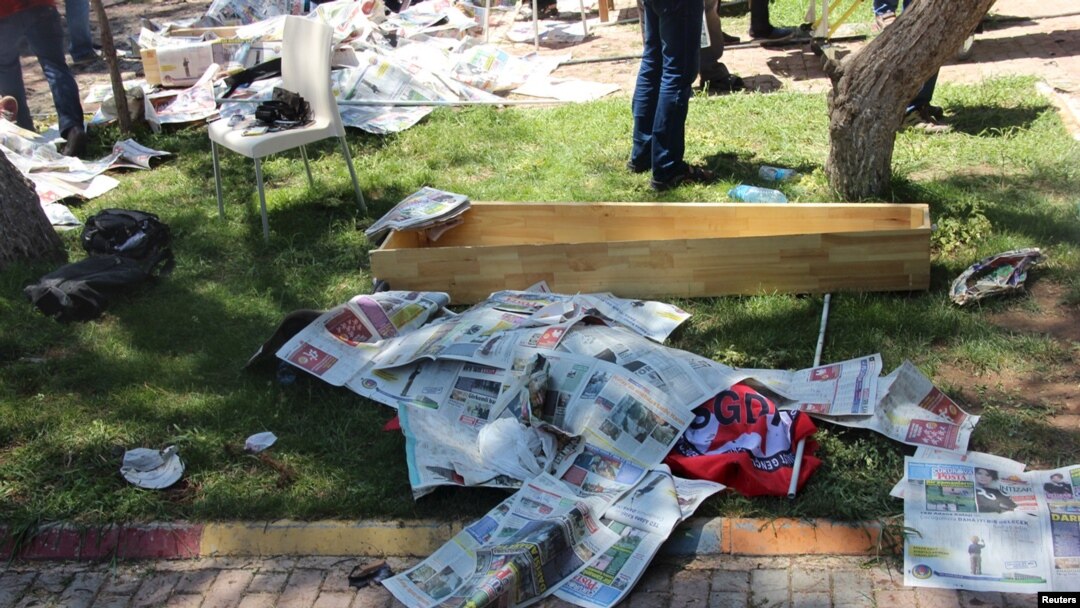 The body of a victim, covered by newspapers, lies next to a coffin after an explosion in Suruc in the southeastern Sanliurfa province, Turkey, July 20, 2015. 