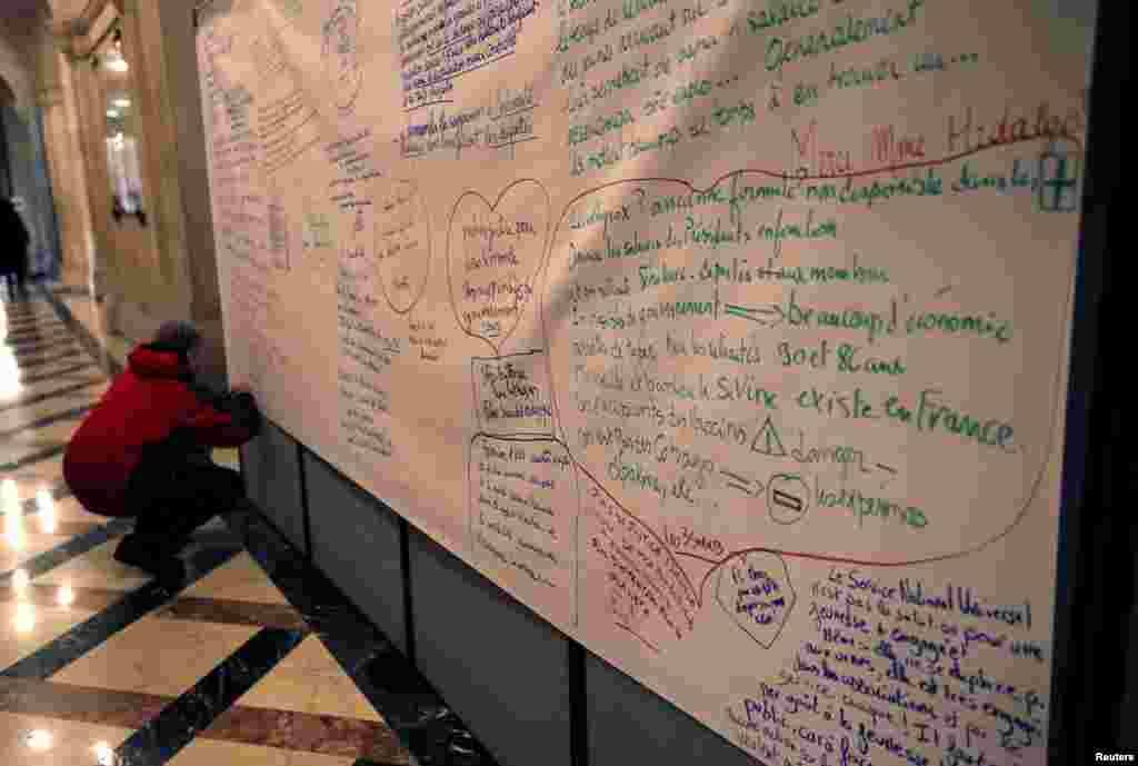 A man writes ideas on a board after attending a session of the &#39;Great National Debate&#39; at the city hall in Paris, France.