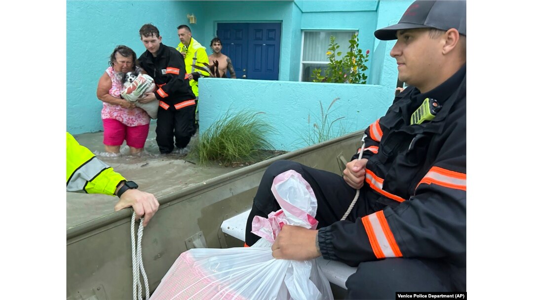 This photo provided by Venice Police Department rescue crews assist residents after conducting door-to-door wellness checks, in coastal areas flooded by Hurricane Helene on Sept. 27, 2024 in Venice, Florida. (Venice Police Department via AP)