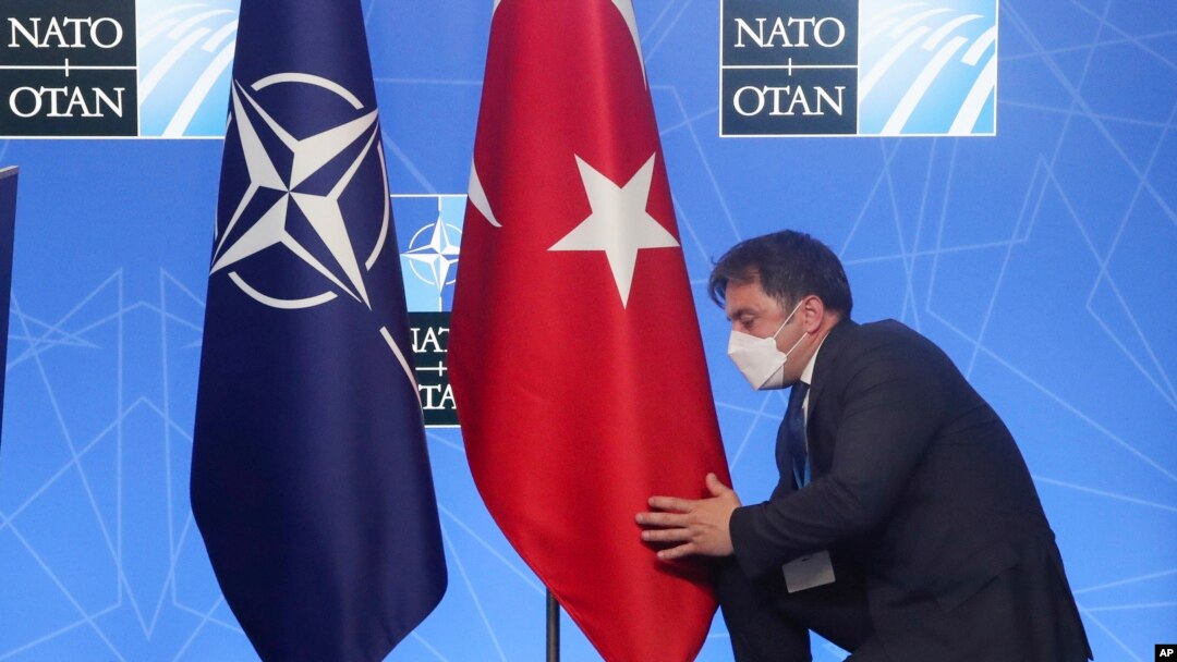 FILE - An official adjusts the Turkish flag prior to a media conference of Turkey's President Recep Tayyip Erdogan at a NATO summit in Brussels, June 14, 2021.
