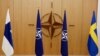 FILE - The flags of Finland, NATO and Sweden are seen during a ceremony to mark Sweden's and Finland's application for membership in Brussels, Belgium, May 18, 2022. 