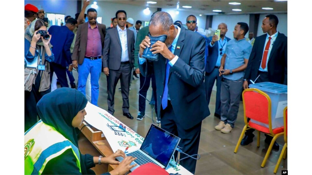Somaliland President Muse Bihi Abdi, center, gets his biometrics registered before casting his vote inside a polling station during the presidential election in Hargeisa, Somaliland, Nov. 13, 2024.