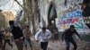 A protester throws stones as others run for cover during clashes with riot police at Tahrir Square in Cairo, November 26, 2012. 