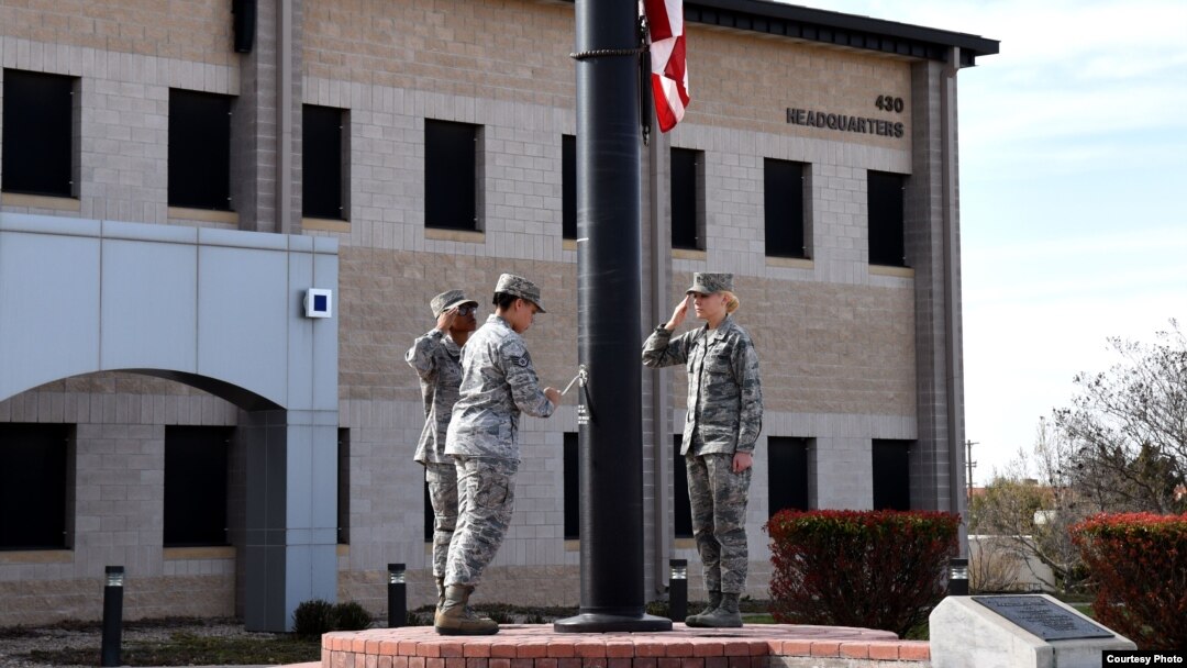 Members of a flag detail lower the flag in front of the Norma Brown Building on Goodfellow Air Force Base, Texas, March 16, 2018. (Airman 1st Class S. Hines / USAF)