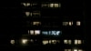 FILE - Apartments are illuminated in a building in Vienna, Austria, March 28, 2020. Incidents of domestic violence have gone up during coronavirus shutdowns.