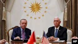 Vice President Mike Pence, left, and Secretary of State Mike Pompeo, walk to a car to drive to a meeting with Turkish President Recep Tayyip Erdogan, in Ankara, Turkey, Oct. 17, 2019. 