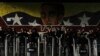 Funcionarios de la Policía Nacional Bolivariana se forman frente a un mural del Libertador Simón Bolívar en Caracas, el 31 de julio de 2024, después de dos días de protestas contra los resultados de la elección presidencial en Venezuela.
