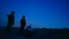 FILE - Russia-backed rebels are seen guarding territory after sunset near Donetsk, eastern Ukraine, Aug. 2, 2015.