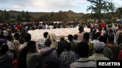 ፎቶ ፋይል፦ በትግራይ ክልል ሽሬ ከተማ ፀሃዬ አንደኛ ደረጃ ትምህርት ቤት በግጭት የተፈናቀሉ ሰዎች ጊዜያዊ መጠለያ ውስጥ የምግብ ልገሳ ለመቀበል ወረፋ በመጠባበቅ ላይ ናቸው።