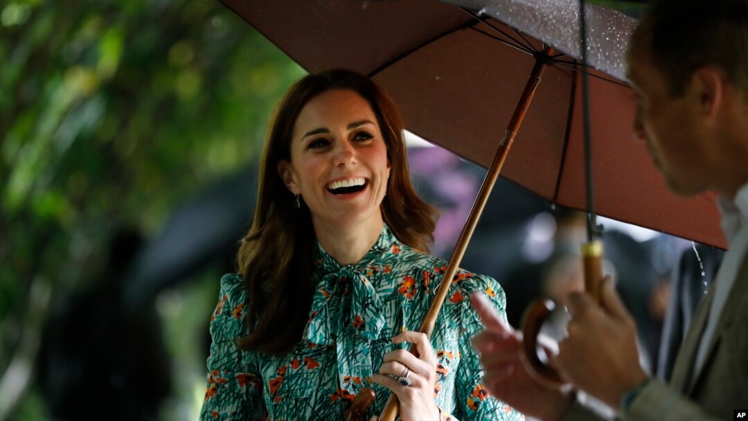 FILE - Britain's Prince William and his wife Kate, Duchess of Cambridge smile as they walk through the memorial garden in Kensington Palace, London, Aug. 30, 2017.