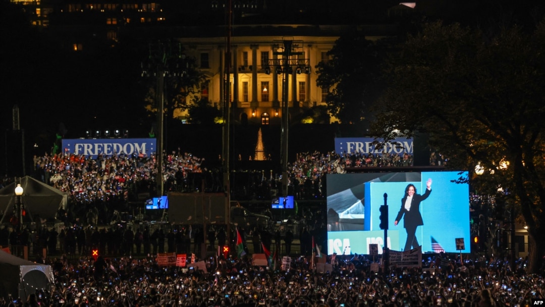 Una pantalla muestra a la vicepresidenta estadounidense y candidata presidencial demócrata, Kamala Harris, saludando mientras llega al escenario para hablar en el Elipse, al sur de la Casa Blanca, en Washington, el 29 de octubre de 2024.
