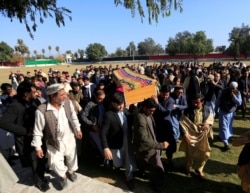 FILE - Afghan men carry the coffin of journalist Malalai Maiwand, who was shot and killed by unknown gunmen in Jalalabad, Afghanistan, Dec. 10, 2020.