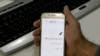 FILE - A man holds a smartphone connected to a Wifi network without internet access, at an office in the Iranian capital Tehran, Nov. 17, 2019.