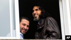 FILE - In this June 5, 2015 file photo, Abu Wa'el Dhiab, from Syria (r) and Adel bin Muhammad El Ouerghi, of Tunisia, both freed Guantanamo Bay detainees, look out the window of their shared home in Montevideo, Uruguay. Abu Wa'el Dhiab, who disappeared in June 2016 in Uruguay, setting off alarm bells in neighboring countries and recriminations in Washington, has reappeared in Venezuela according to Uruguay's Foreign Minister Rodolfo Nin Novoa on Wednesday, July 27, 2016.