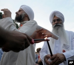 FILE - People gather in Lafayette near the White House, Aug. 8, 2012 to participate in a candlelight vigil against hate violence.