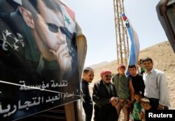 FILE - Syrian refugees who left Lebanon arrive in Qalamoun, Syria, June 28, 2018.