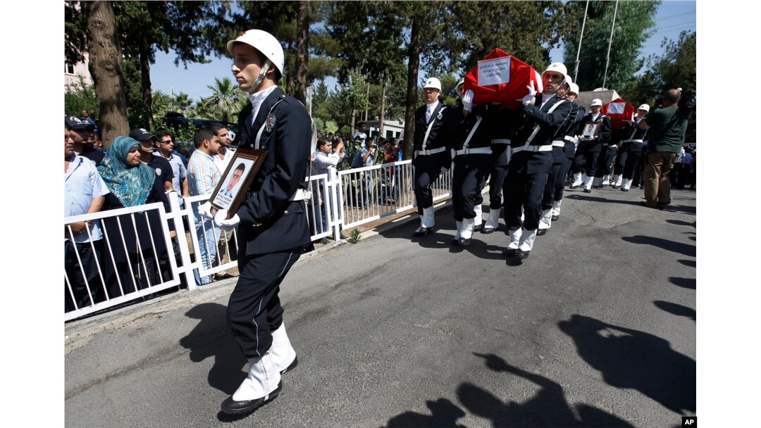 FILE - Turkish police officers carry the coffins of police officers Feyyaz Yumusak and Okan Acar, during a funeral procession in Sanliurfa, southeastern Turkey, July 23, 2015.