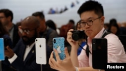 FILE - A demonstration of the newly released Apple products is seen following the product launch event at the Steve Jobs Theater in Cupertino, California, Sept. 12, 2018.