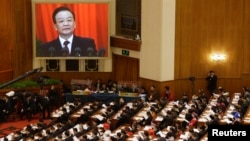 China's Premier Wen Jiabao (shown on screen) speaks as delegates listen during the opening ceremony of National People's Congress (NPC) at the Great Hall of the People in Beijing, March 5, 2013. 