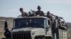 FILE - Ethiopian government soldiers ride in the back of a truck on a road near Agula, north of Mekele, in the Tigray region of northern Ethiopia, May 8, 2021.