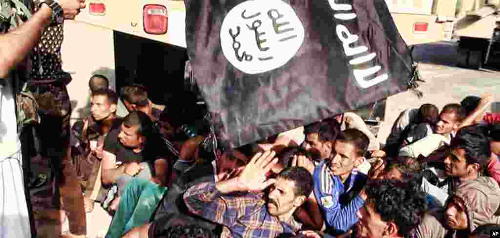 This image posted on a militant website on June 14, 2014 appears to show militants from the Islamic State of Iraq and the Levant with captured Iraqi soldiers wearing plain clothes after taking over a base in Tikrit, Iraq.